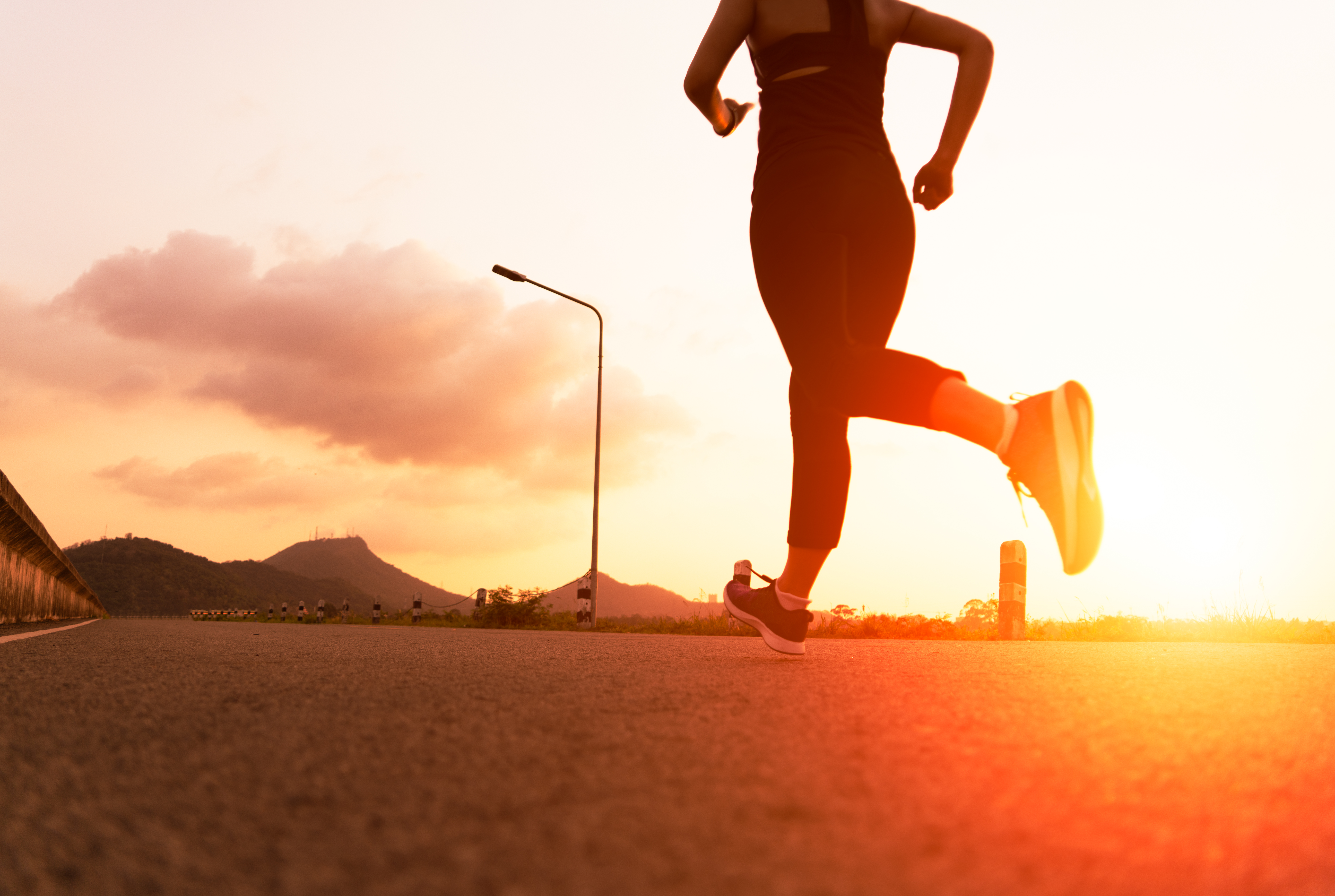 sport woman running on a road. Fitness woman training at sunset