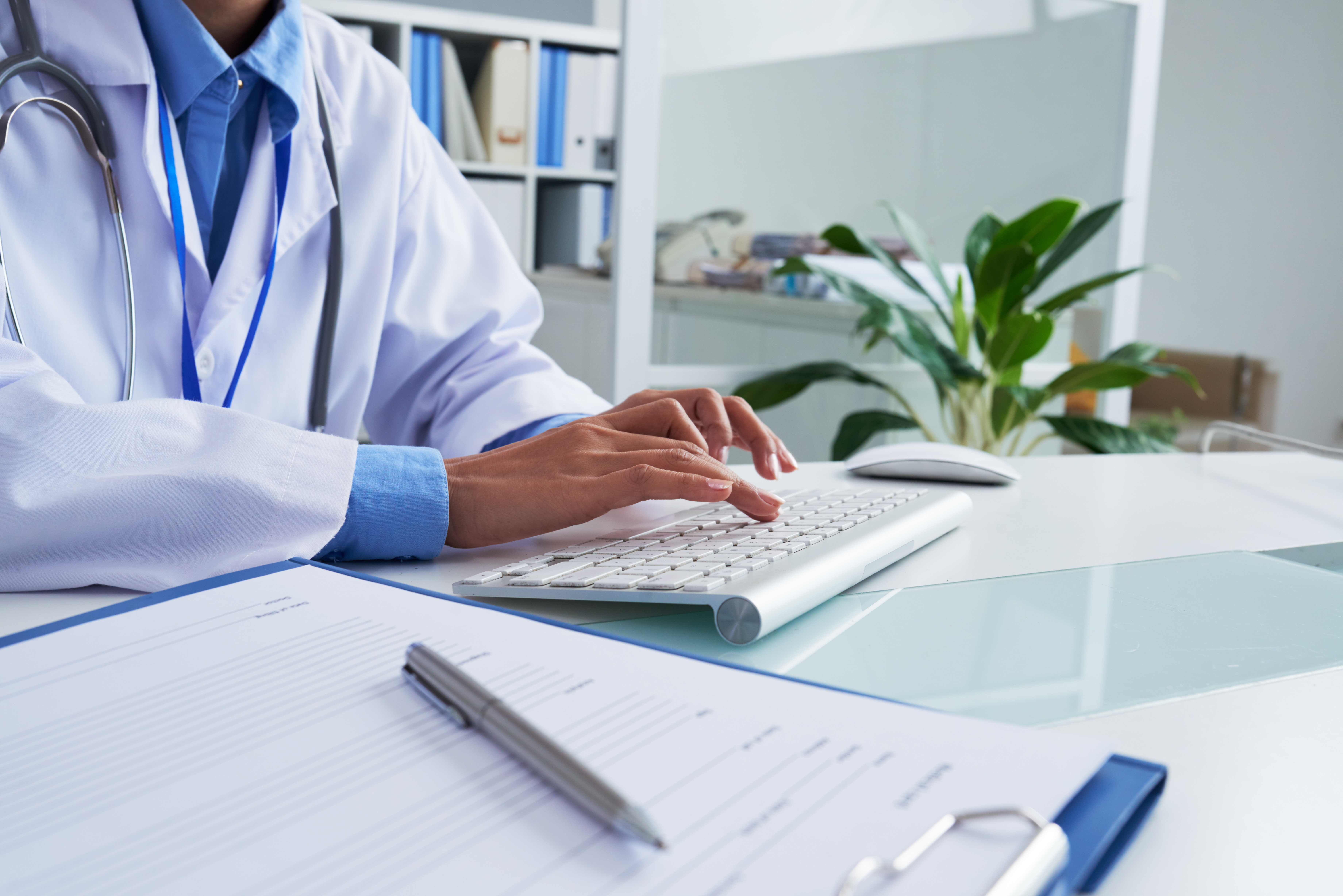 Hands of female doctor typing on keyboard